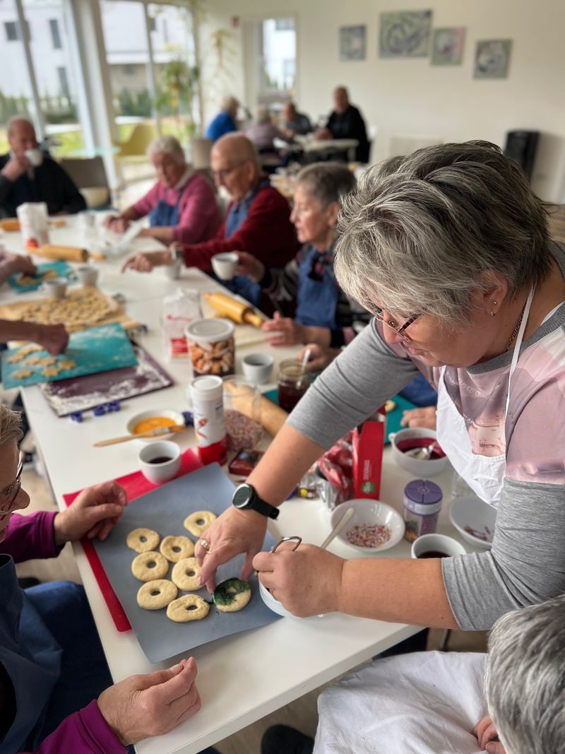 Seniorinnen und Senioren in der Tagespflege Lonsee verzieren Weihnachtsplätzchen